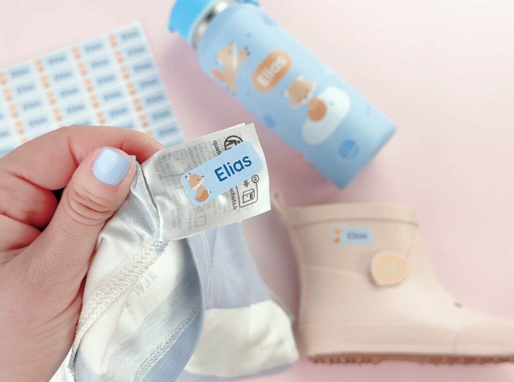 Blå navnelapp med rev og navnet elias på en t-skjorte